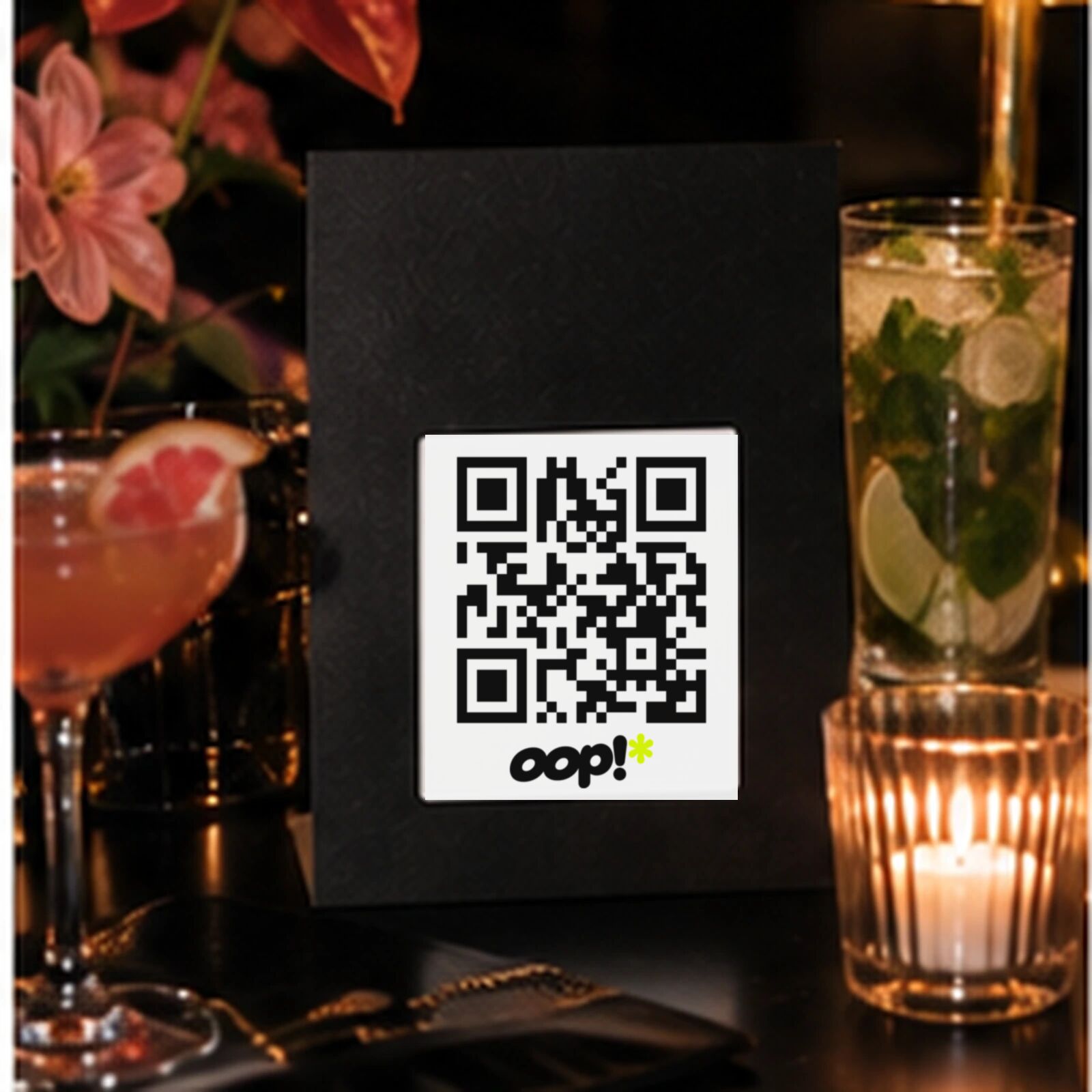 An oop card beside a mojito and a candle